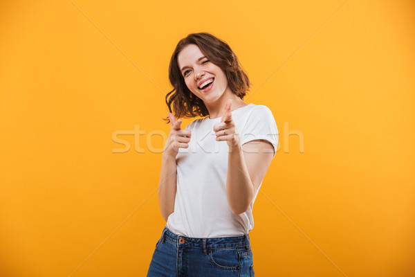 Happy emotional young woman pointing to you. Stock photo © deandrobot