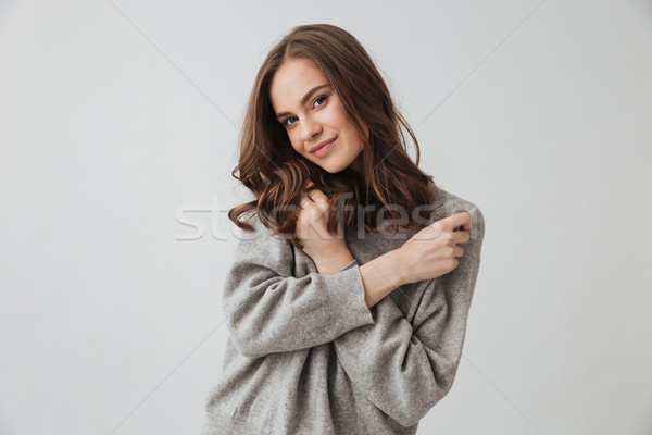 Pleased brunette woman in sweater posing with crossed arms Stock photo © deandrobot