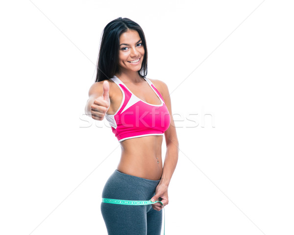 Fitness woman measure her buttocks with a measuring tape Stock photo © deandrobot
