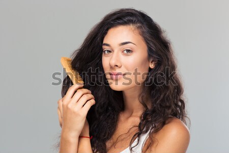 Happy cute woman combing her hair Stock photo © deandrobot