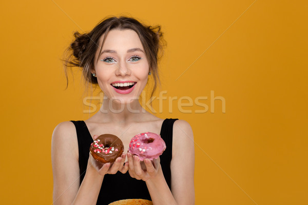 Smiling beautiful young female showing pink and brown donuts  Stock photo © deandrobot