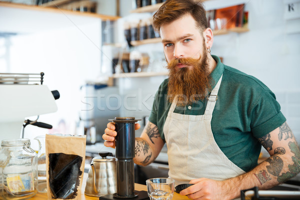 Handsome young man preparing coffee Stock photo © deandrobot