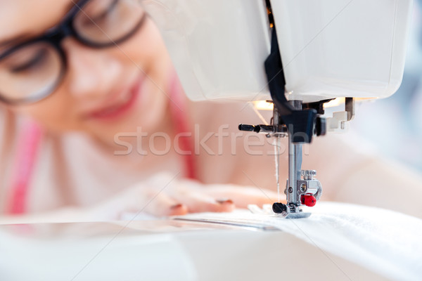 Woman in glasses sews on the sewing machine Stock photo © deandrobot