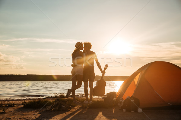 Blick zurück Paar Gitarre Sonnenuntergang schönen Stock foto © deandrobot