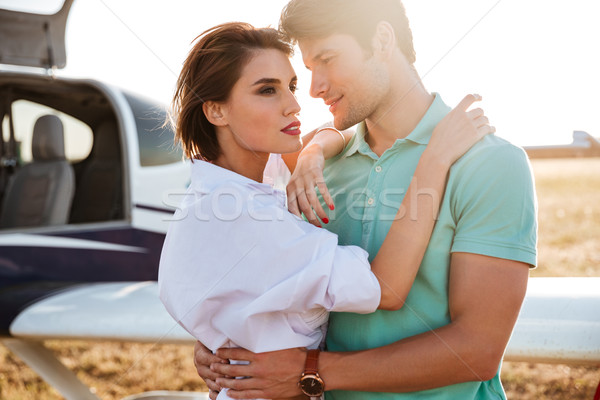 Couple standing and hugging near private aircraft Stock photo © deandrobot