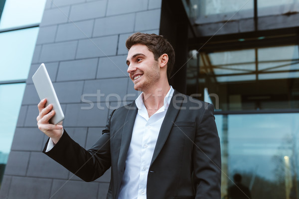 Business man with laptop near the office Stock photo © deandrobot