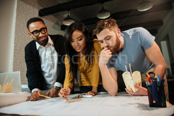 Architects working late at night while looking on project Stock photo © deandrobot