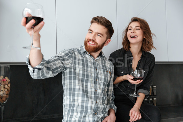 Smiling loving couple standing in kitchen at home indoors Stock photo © deandrobot