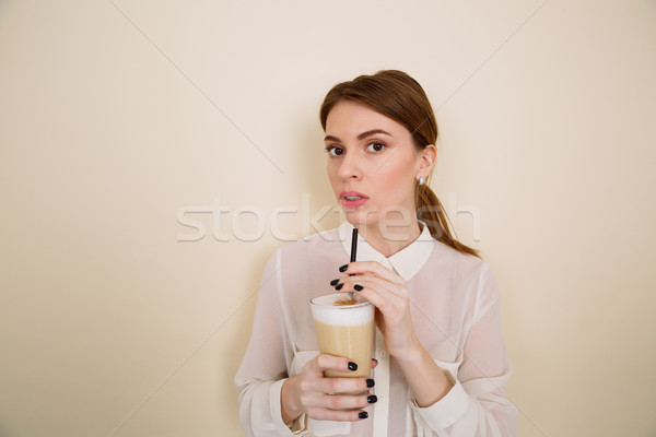 Attractive young woman drinking coffee latte from glass with straw Stock photo © deandrobot