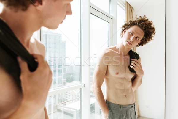 Knappe man naar spiegel foto gekruld home Stockfoto © deandrobot