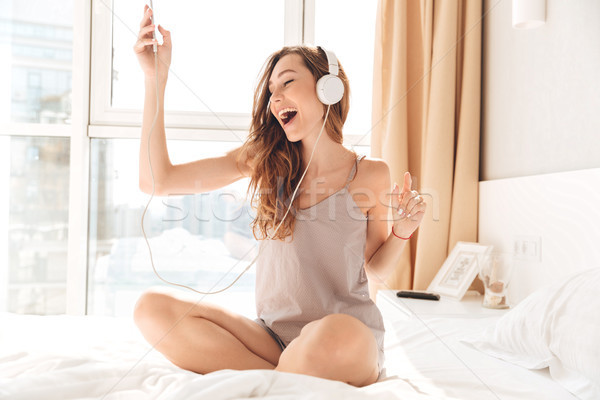 Сток-фото: молодые · счастливым · женщину · прослушивании · музыку · наушники