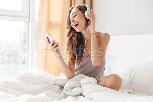 [[stock_photo]]: Joli · dame · écouter · musique · lit · maison