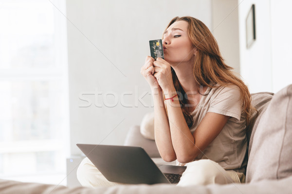 Funny young woman kiss her credit card Stock photo © deandrobot