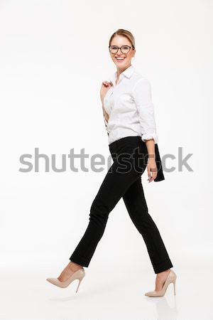 Full length side view image of smiling blonde business woman Stock photo © deandrobot