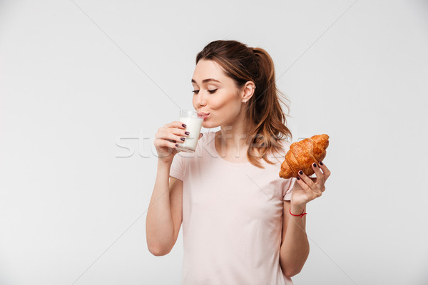 Retrato bastante menina alimentação croissant potável Foto stock © deandrobot