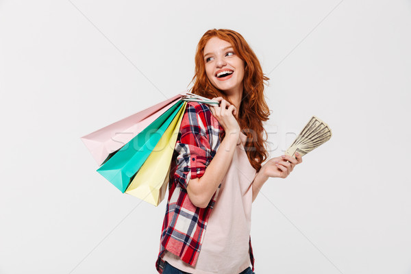 Pleased ginger woman in shirt holding packages on shoulder Stock photo © deandrobot