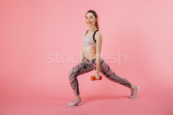 Side view of happy sportswoman doing exercise with dumbbells Stock photo © deandrobot