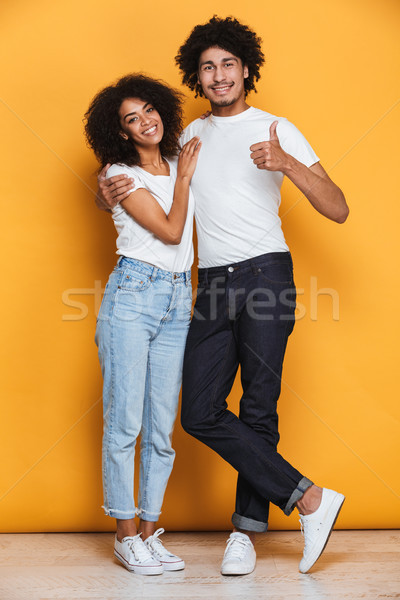 Full length portrait of a smiling young afro american couple Stock photo © deandrobot