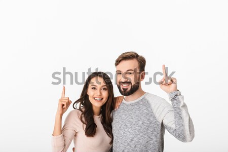 Cheerful young loving couple pointing. Stock photo © deandrobot
