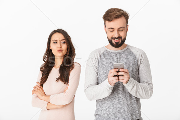 Elégedetlen fiatal nő néz férfi mobiltelefon kép Stock fotó © deandrobot