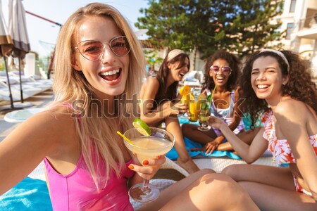 Back view image of four cheerful young women Stock photo © deandrobot