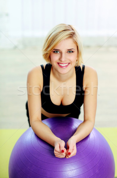 Young happy fit woman leaning on the fitball Stock photo © deandrobot