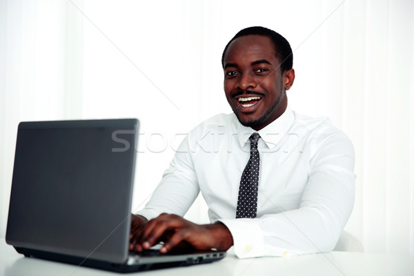 [[stock_photo]]: Heureux · africaine · homme · utilisant · un · ordinateur · portable · bureau · portable