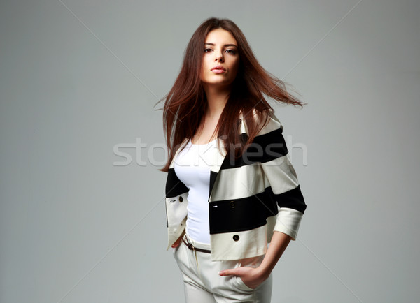 Portrait of a young beautiful woman in casual clothes on gray background Stock photo © deandrobot