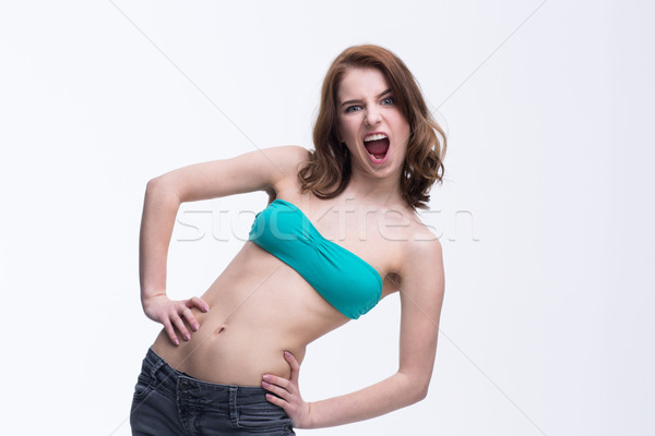 Young beautiful woman screaming over gray background Stock photo © deandrobot