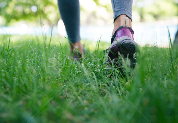 Footwear on female feet running on green grass Stock photo © deandrobot