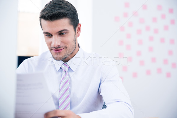 Businessman reading document in office Stock photo © deandrobot