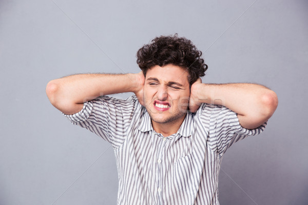 Casual man covering his ears  Stock photo © deandrobot
