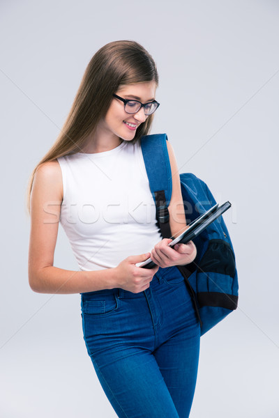 Stock photo: Female teenager with backpack using tablet computer