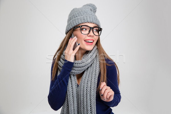 Smiling woman talking on the phone and looking away Stock photo © deandrobot