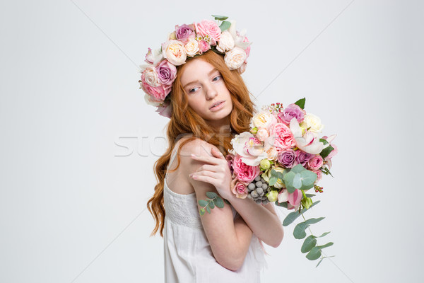 Tender charming woman in wreath posing with bouquet of flowers Stock photo © deandrobot