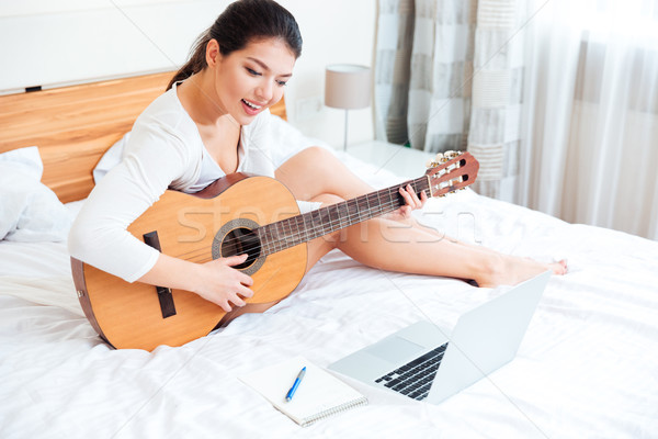 Stock foto: Frau · spielen · Datensätze · Gitarre · Laptop-Computer · lächelnde · Frau