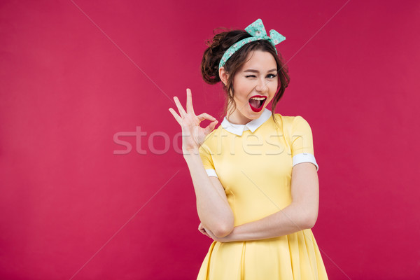 Cute playful pinup girl winking and showing ok sign Stock photo © deandrobot