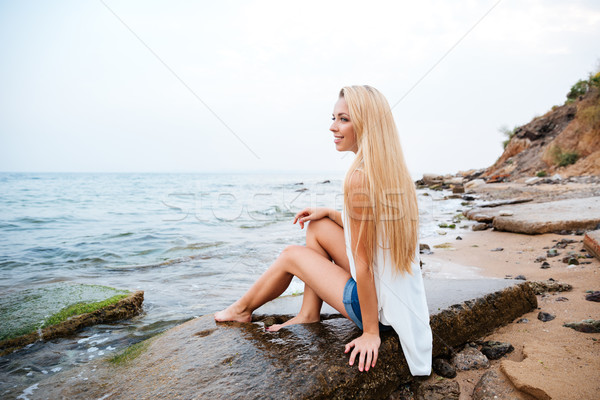 Donna sorridente lungo capelli biondi seduta spiaggia sorridere Foto d'archivio © deandrobot