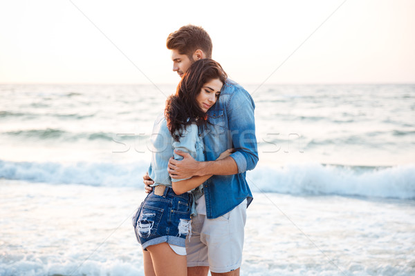 Couple standing and hugging on the beach Stock photo © deandrobot