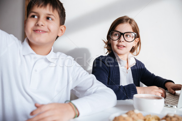 Two happy little children learning and using laptop Stock photo © deandrobot