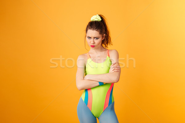 Triste mulher jovem atleta em pé amarelo Foto stock © deandrobot