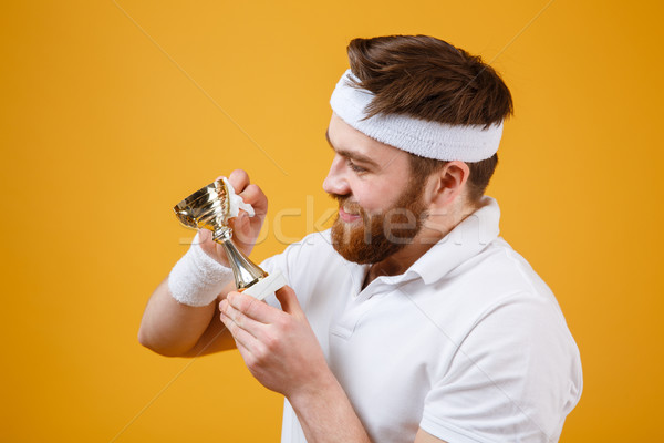 Stock photo: Happy young sportsman holding reward and wipe with a napkin