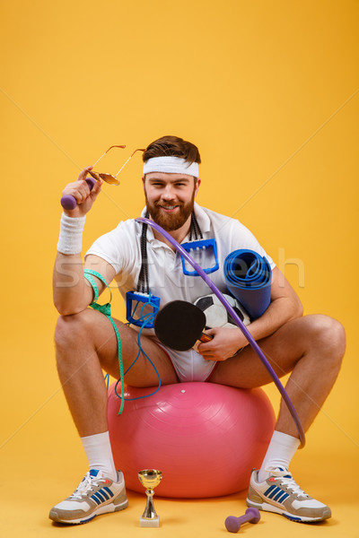 Portrait of a sports man sitting on a fitness ball Stock photo © deandrobot