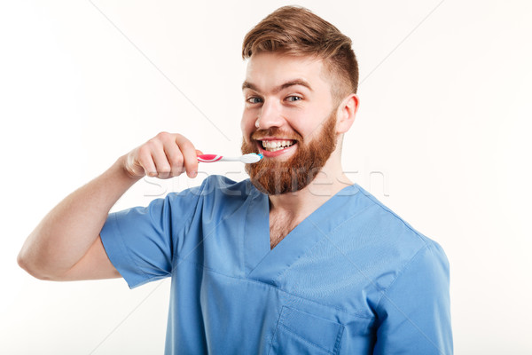 Portrait of young dentist teaching patient how to brush teeth Stock photo © deandrobot