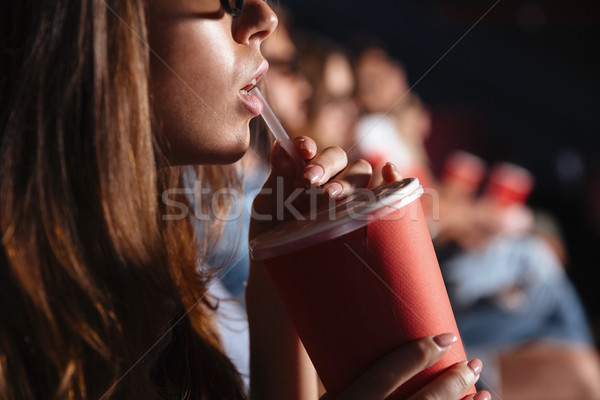 Cropped picture of young lady sitting in cinema Stock photo © deandrobot