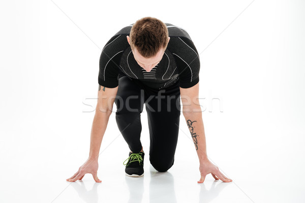 Portrait of a concentrated male sprinter preparing to start running Stock photo © deandrobot
