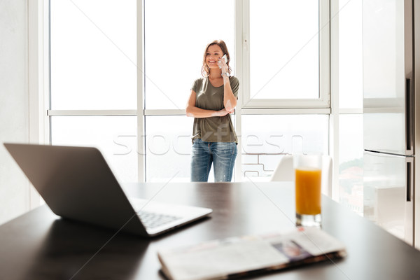 Happy casual woman talking on smartphone Stock photo © deandrobot