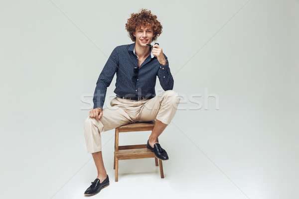 Positive retro man dressed in shirt sitting and posing Stock photo © deandrobot