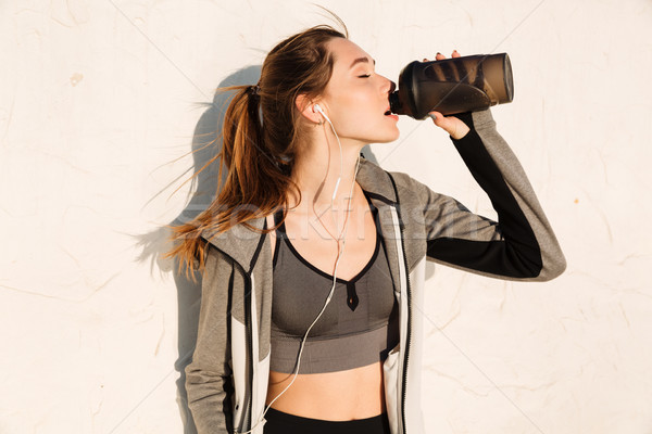 Stock photo: Close-up portrait of charming brunette sport woman drinking wate