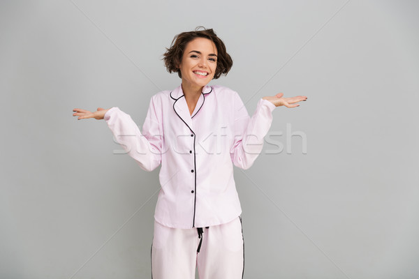 Portrait of a happy girl in pajamas holding copy space Stock photo © deandrobot